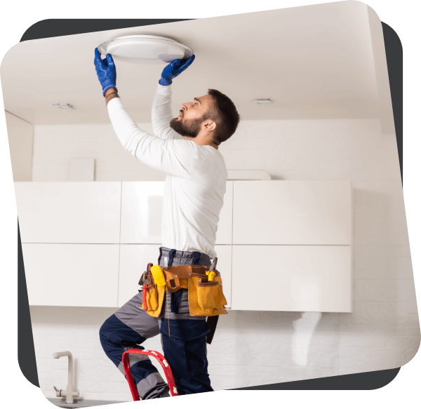 Electrician changing lamp in kitchen